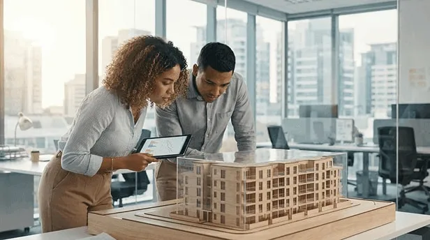 Jovem casal da Geração Z analisando projeto imobiliário e gráficos financeiros em um ambiente moderno e iluminado.